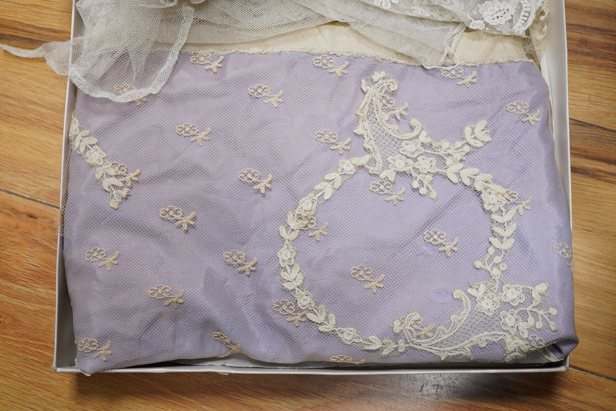 A small late 19th century Brussels wedding veil, an earlier Brussels bobbin bonnet veil, two needle run bonnet veils, various lace sleeves and a lilac silk and lace coverlet., Brussels veil 140cm x 132cm. Condition - the